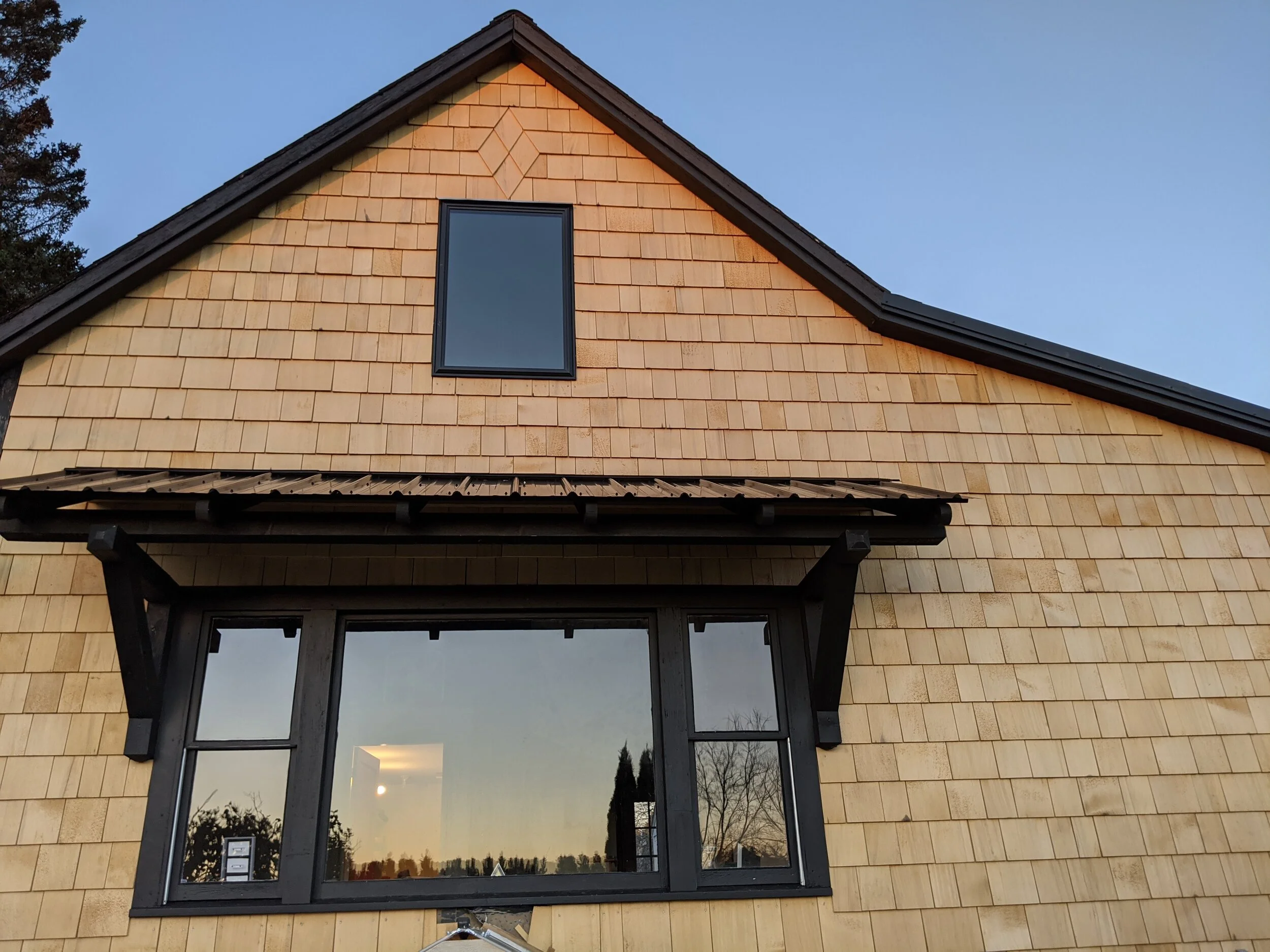Fresh Alaska yellow cedar  shingle siding and an awning roof. September 2020
