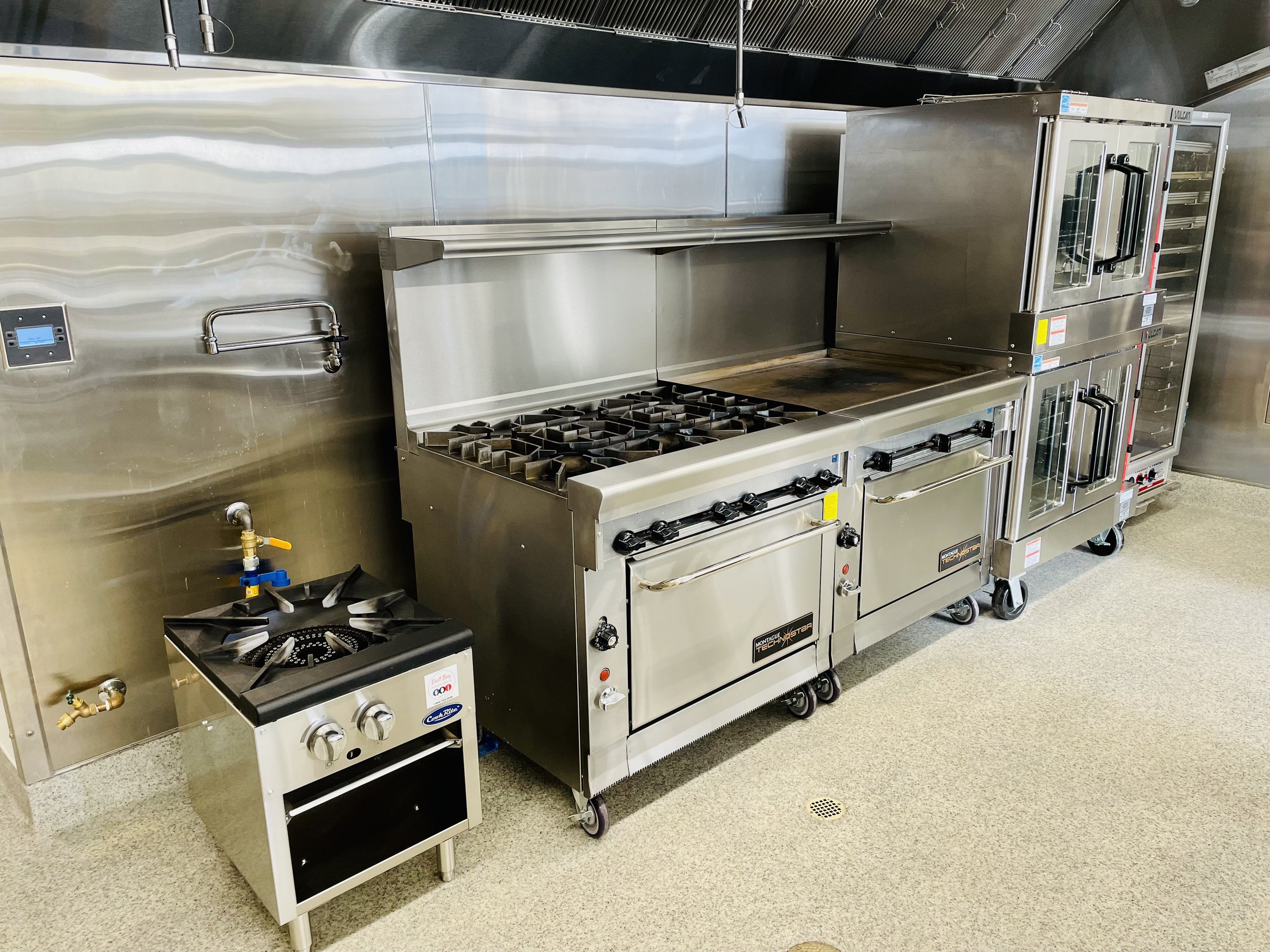 Commercial Kitchen with two large ovens, stove, griddle, convection ovens, warmer/proofer, and large pot stove
