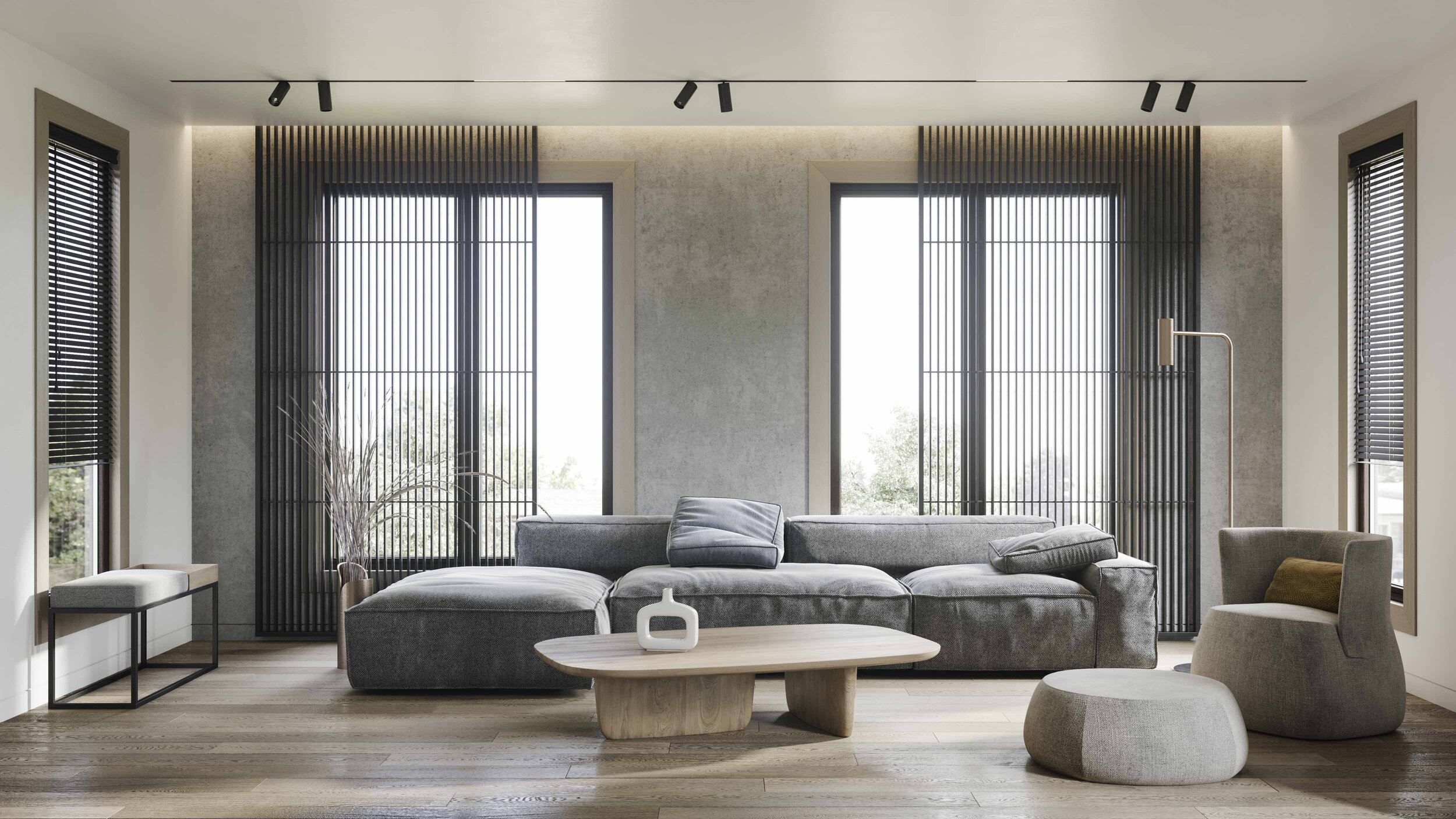 Modern living room interior with a minimalist design, featuring a large gray sectional sofa, a light wood coffee table, and sleek black window treatments. The room is brightened by natural light from tall windows