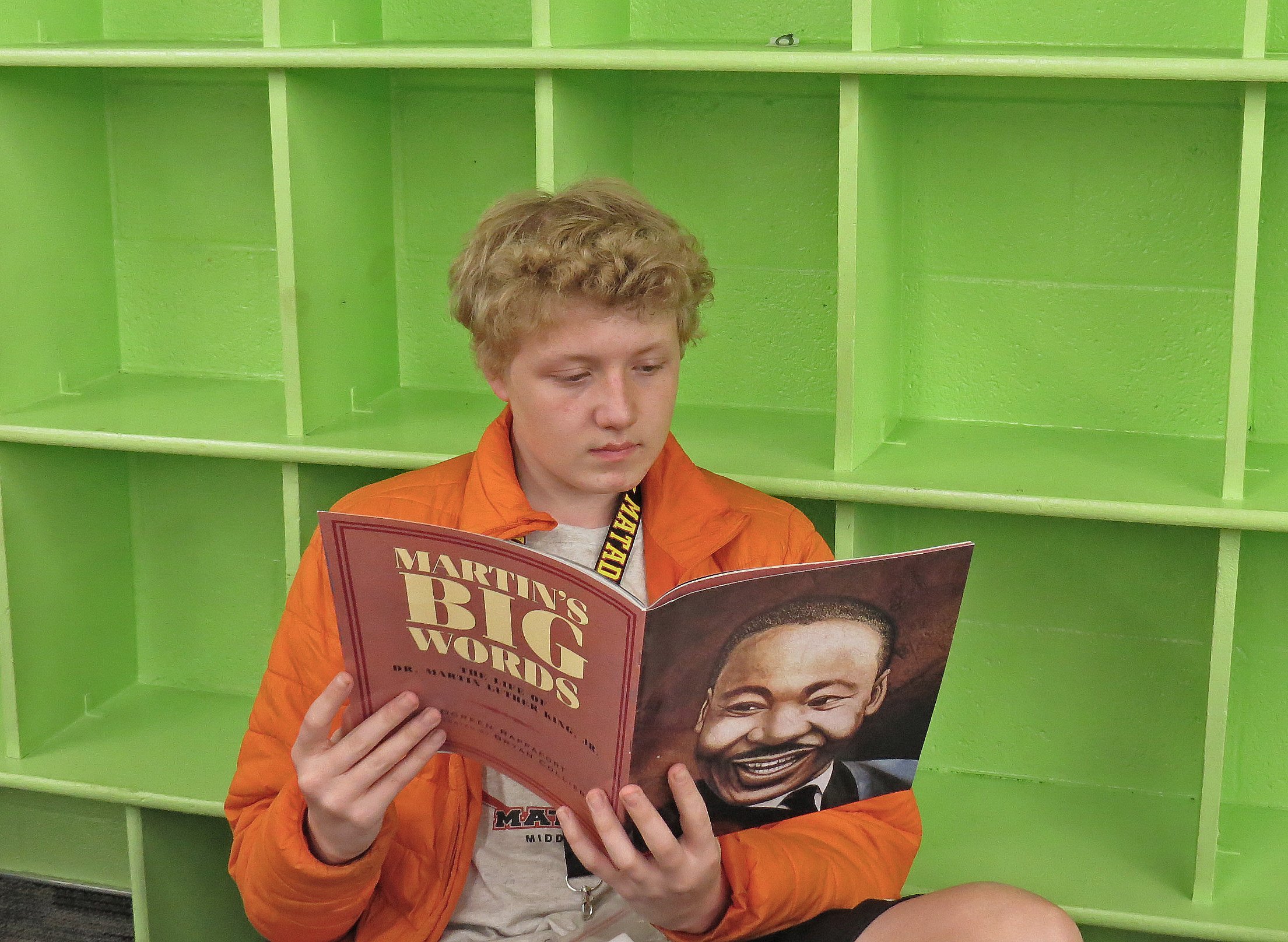kid_reading_book_green_cubby.jpg