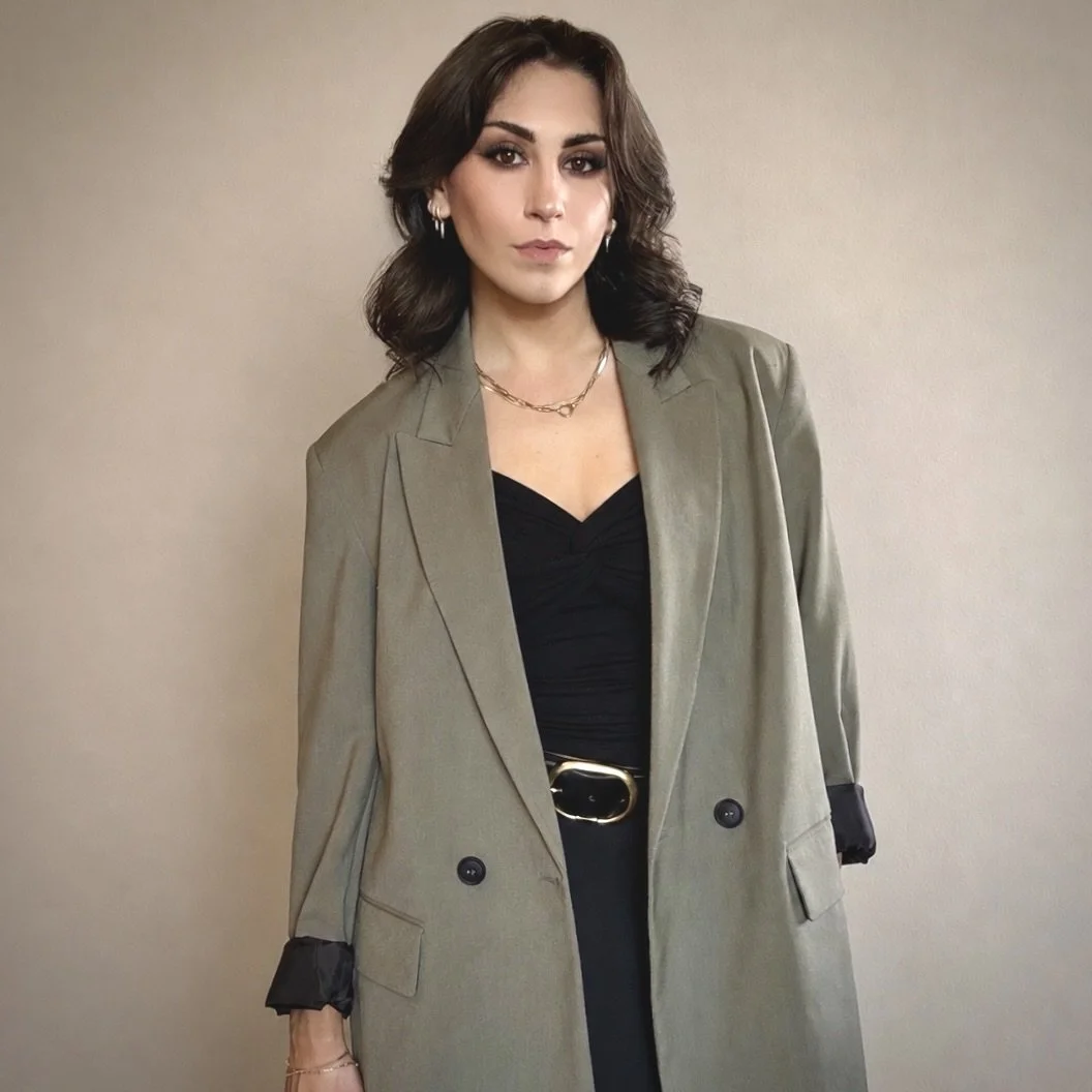 dark brunette woman in an olive green blazer