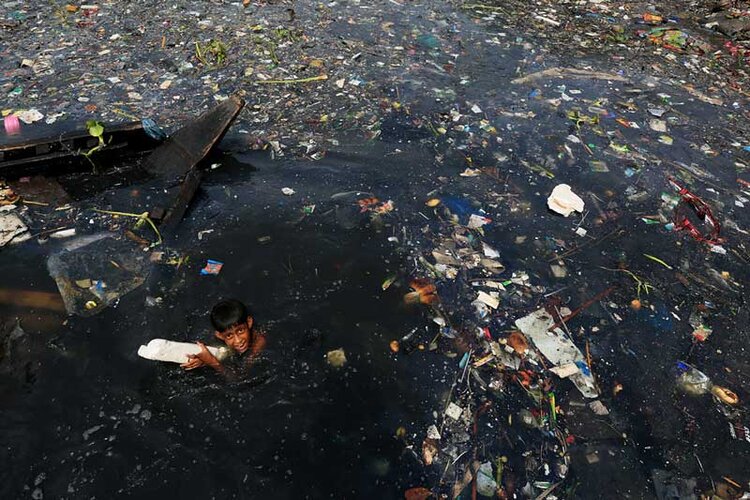 Dye and tannery chemicals pollute the Buriganga River, here we see a child playing in it. Photo: Mahfuzul Hasan Bhuiyan