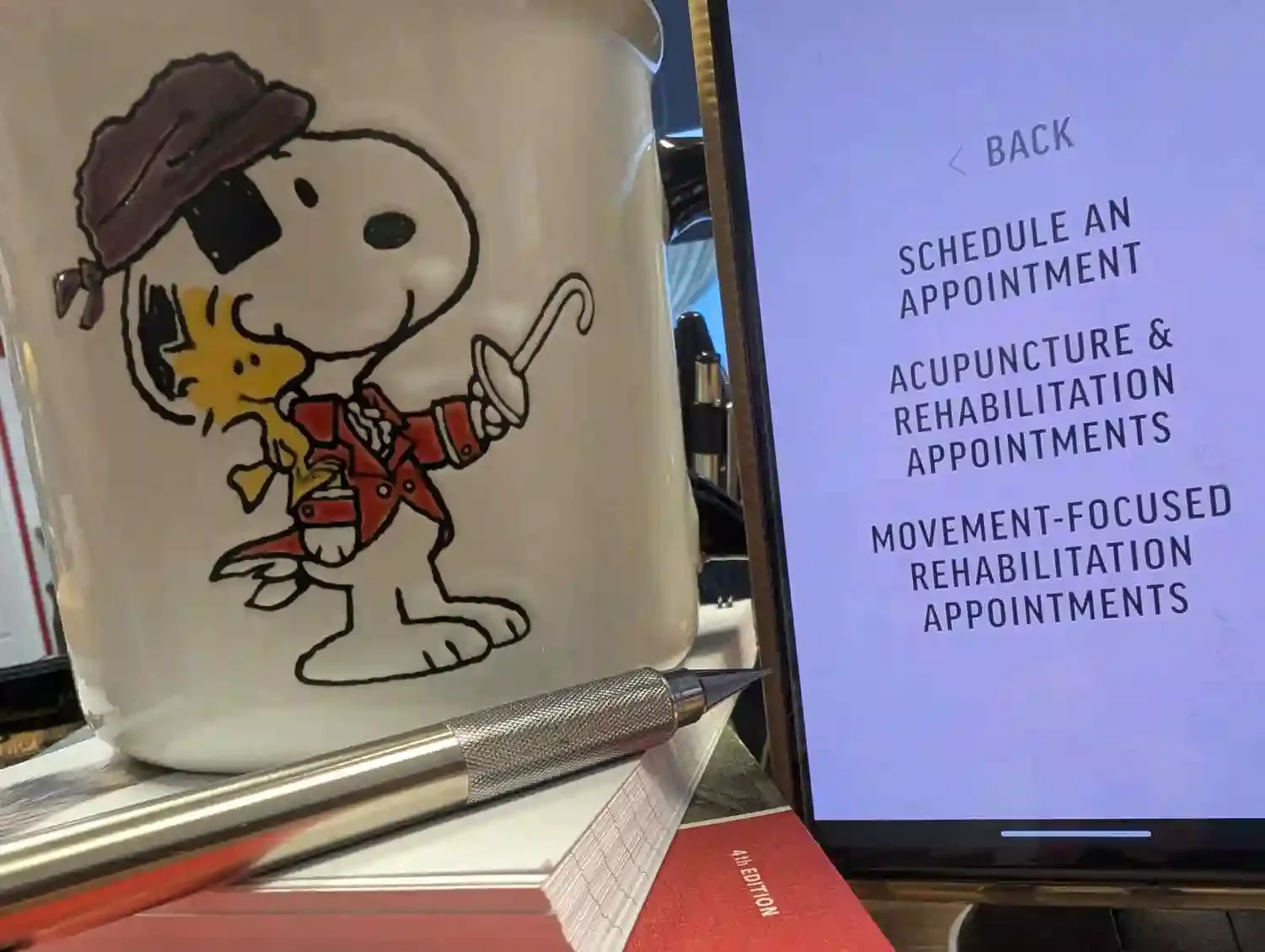 Ruff Day Vet's online scheduling page displayed on a smartphone, with a Snoopy mug in the background. The photo symbolizes a seamless, user-friendly appointment process.