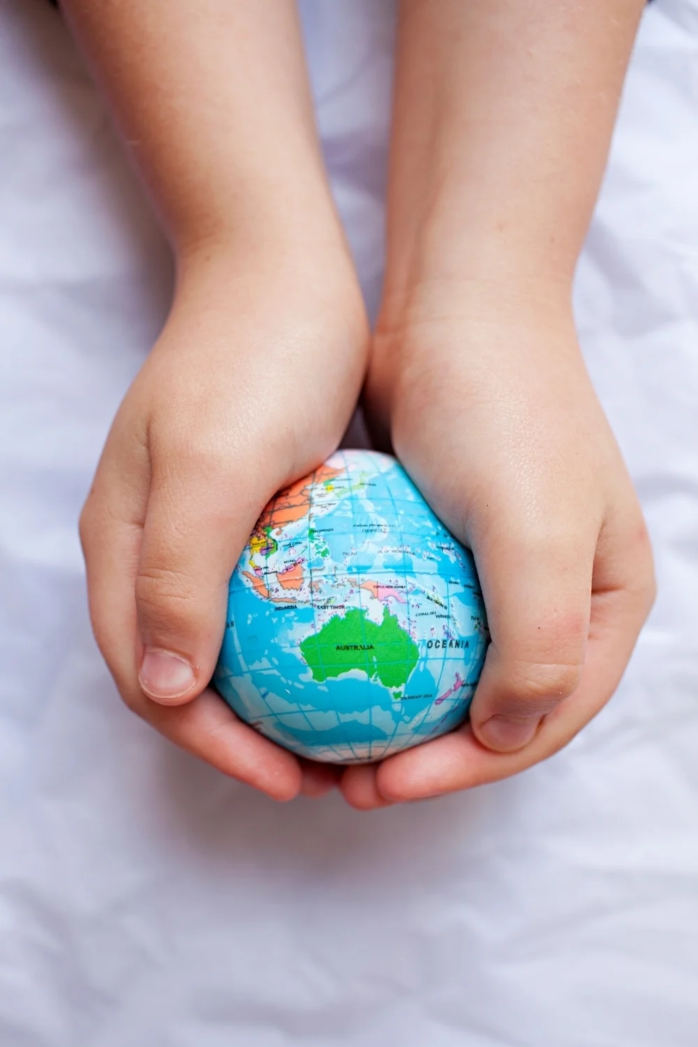 Child's hands hold globe showing Australia.jpg