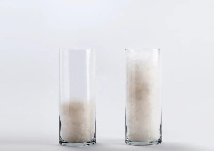 Both jars are filled with the same amount of down. The left jar shows non-treated down and the right jar shows NF5 treated down.
