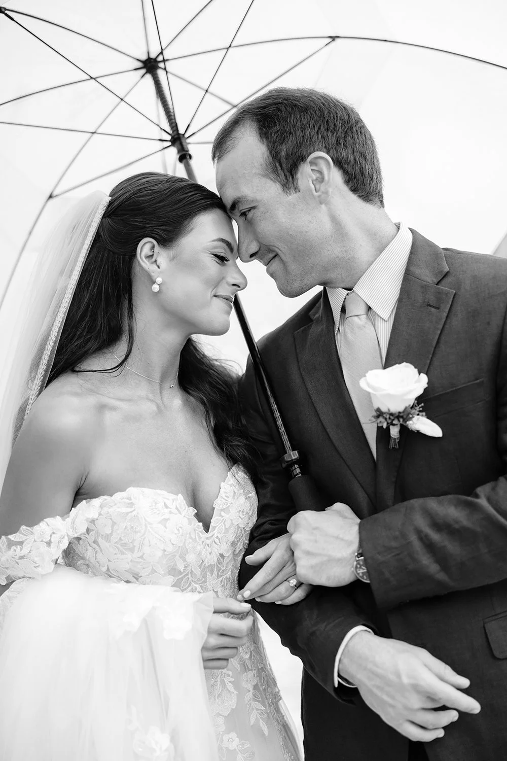 22 Artistic portrait of bride and groom smiling hugging walking over the rain with an umbrella in cancun.jpg