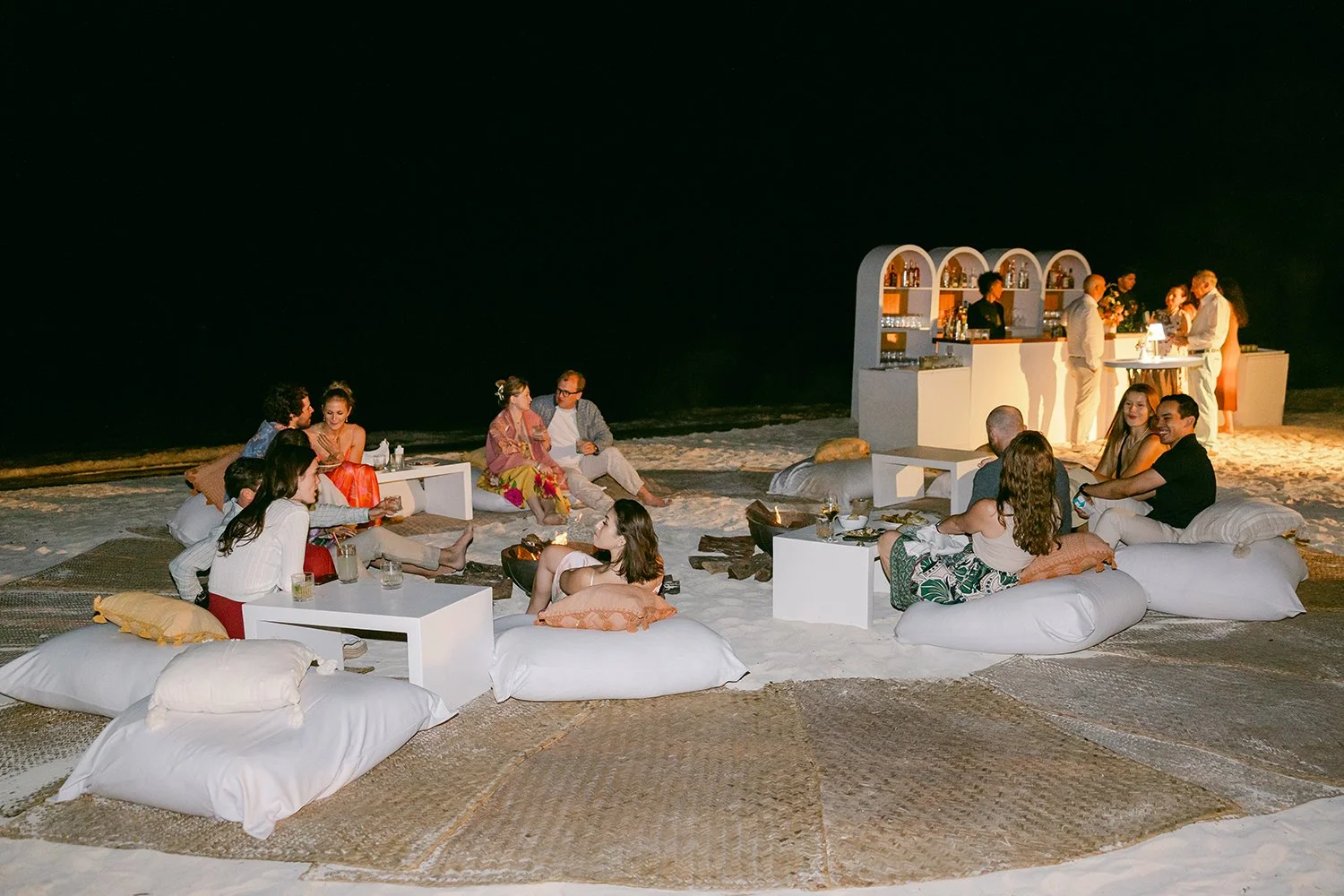 20 welcome party guests by the bonfire at night in the beach.JPG