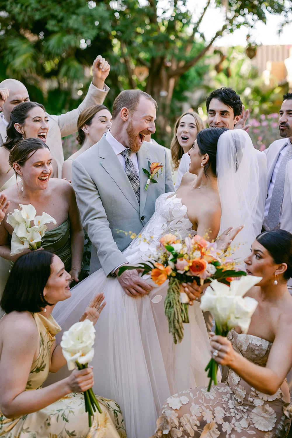 31 incredible detail photo of bride and groom smiling looking at each other with bridal party laughing celebrating.JPG