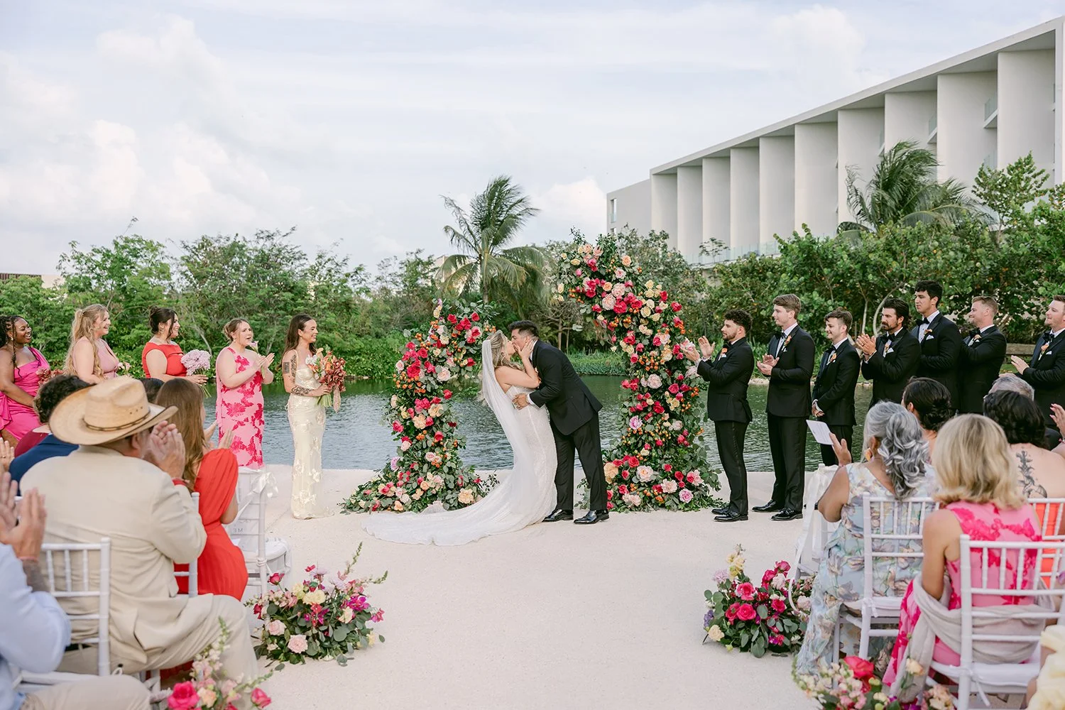 33 bride and groom kissing first kiss and wedding guests celebrating.JPG