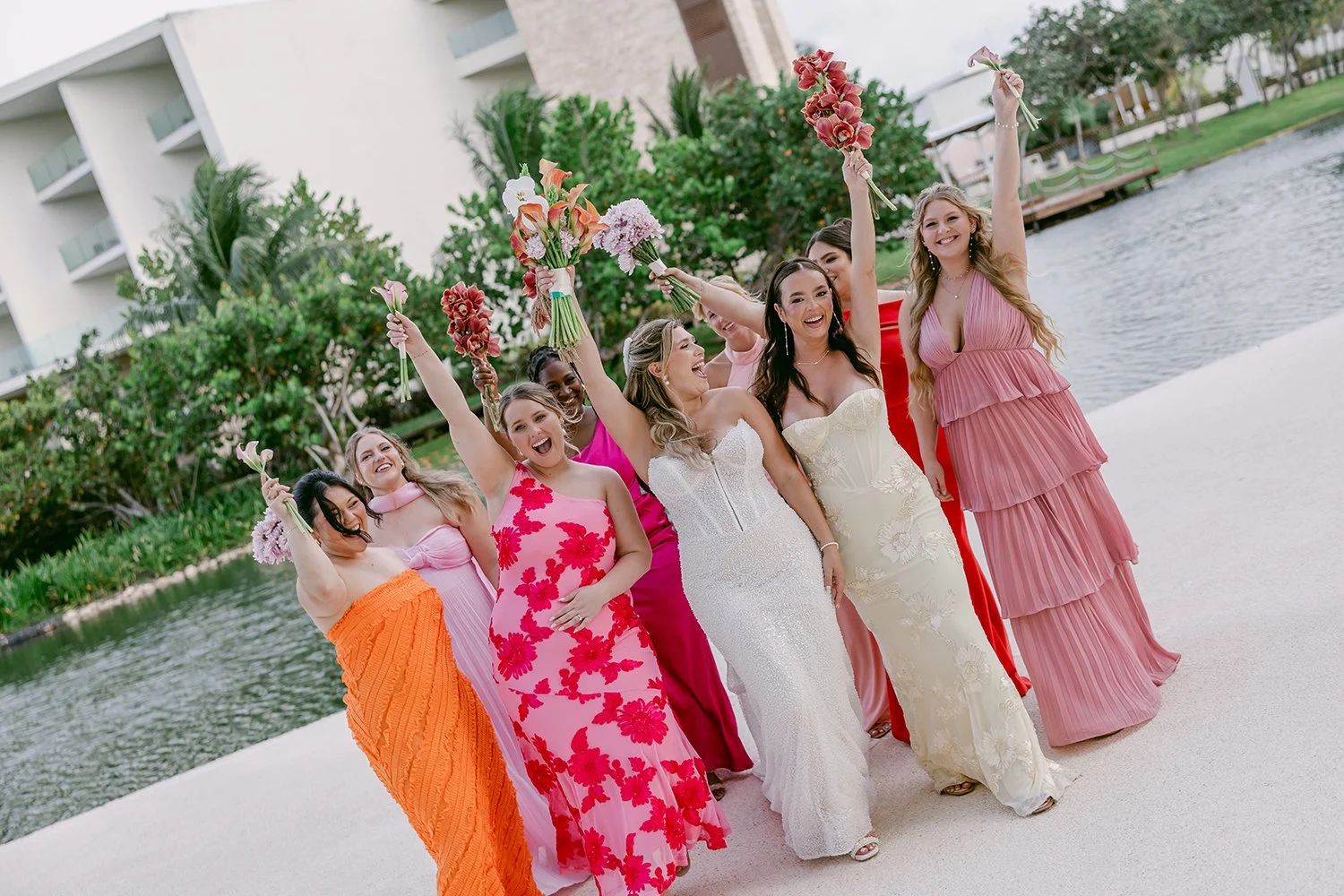 44 bride with her bridesmaids celebrating lifting up their bouquets of flowers.JPG