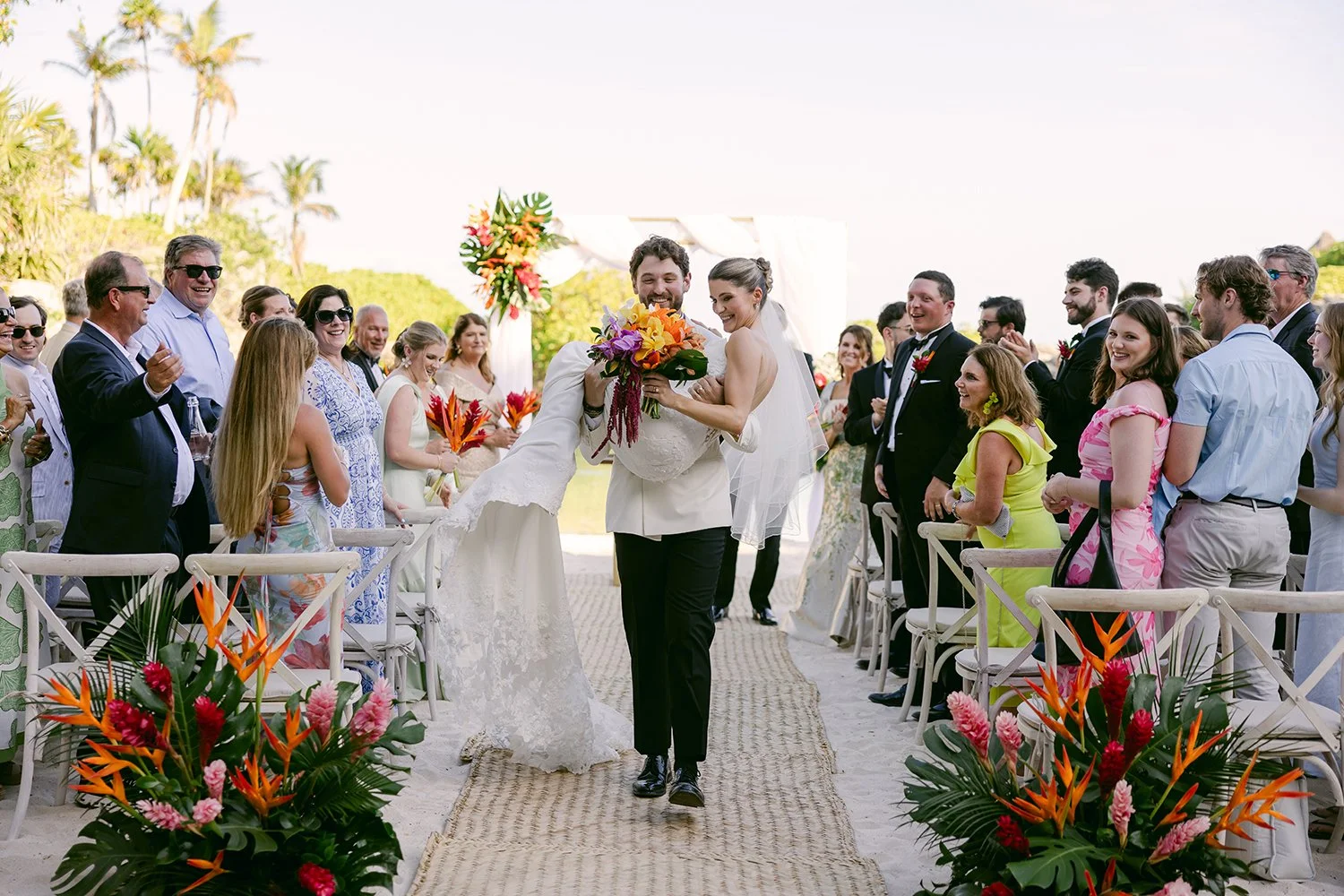 31 groom carrying bride in his arms walking down the isle happily.JPG