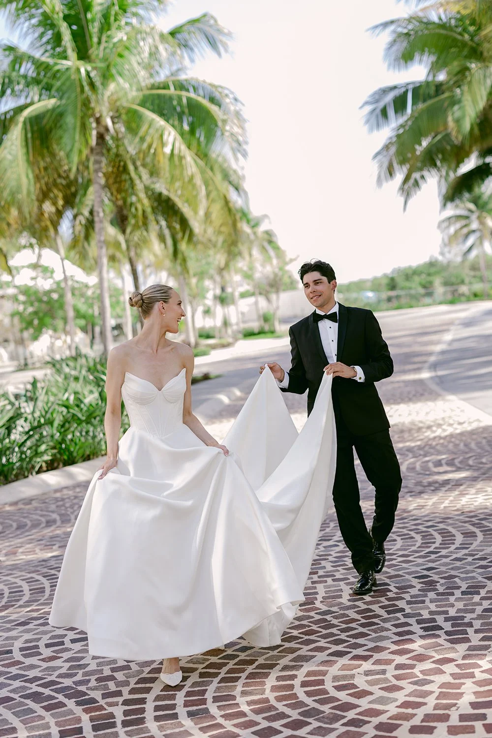 29 bride and groom walking, groom helping bride carrying her white wedding dress.JPG