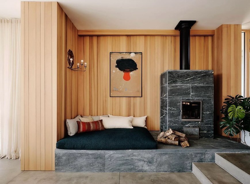 We would like to volunteer to cozy up on a bed upholstered in our Sorbonne fabric, next to a stone fireplace, surrounded by beautiful natural wood tones and fantastic art! Designed by @pappasmirondesign , this nook is certainly calling our name. Swip