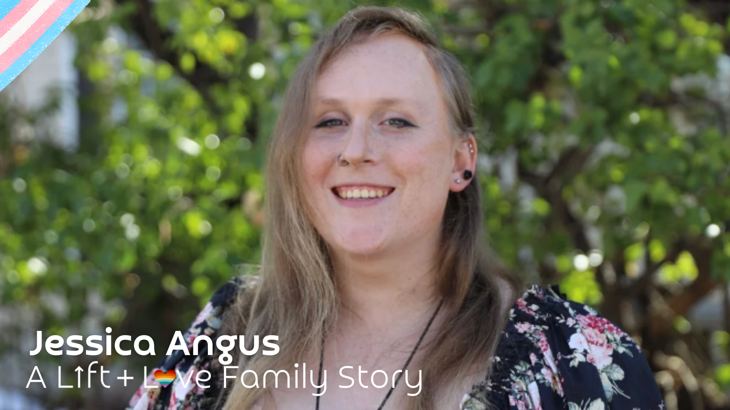 A woman with long blonde hair and multiple ear piercings smiling outdoors with green trees in the background.
