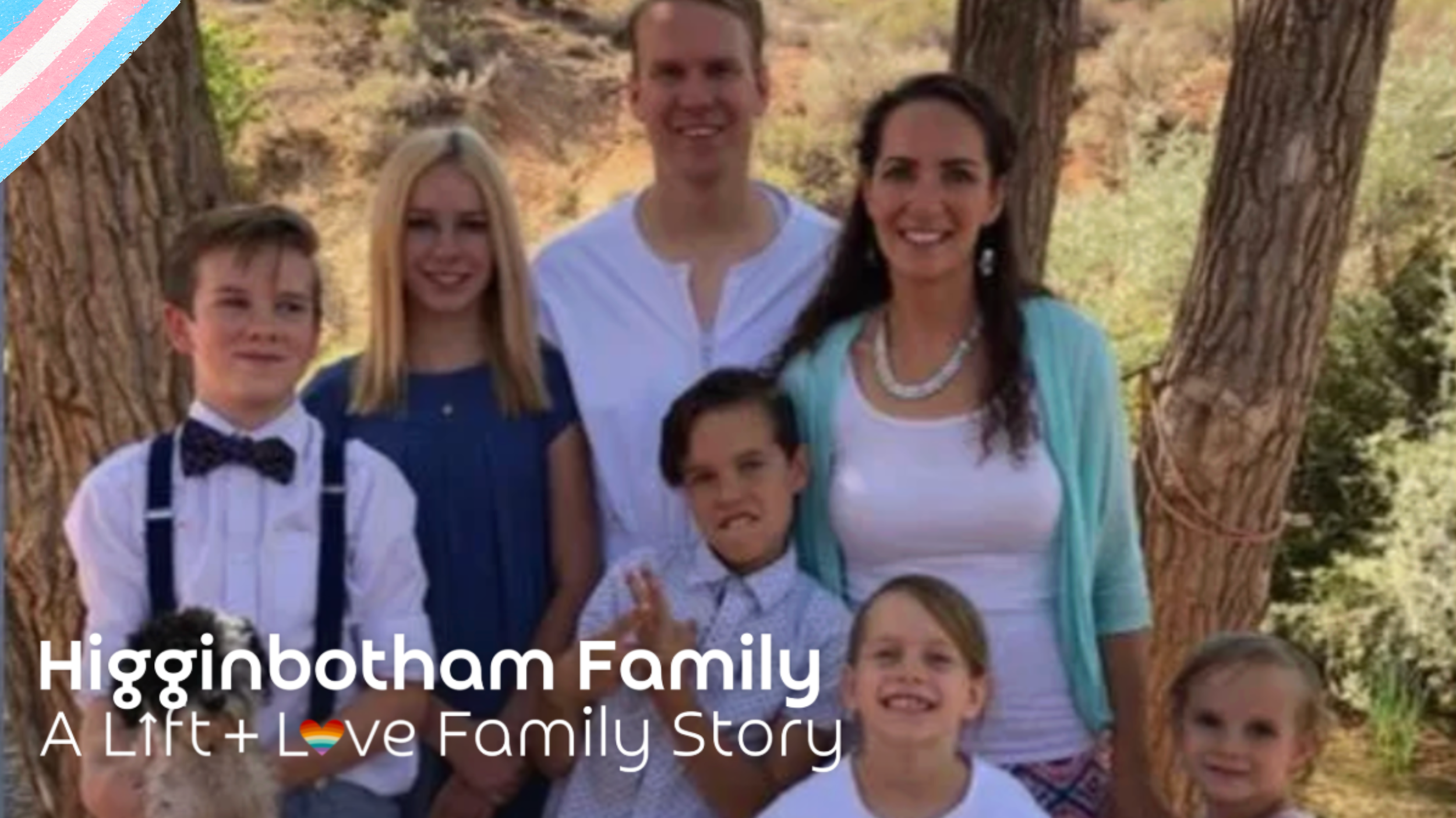 A family of eight posing outdoors near trees, including three adults and five children, with a dog in the front left corner.