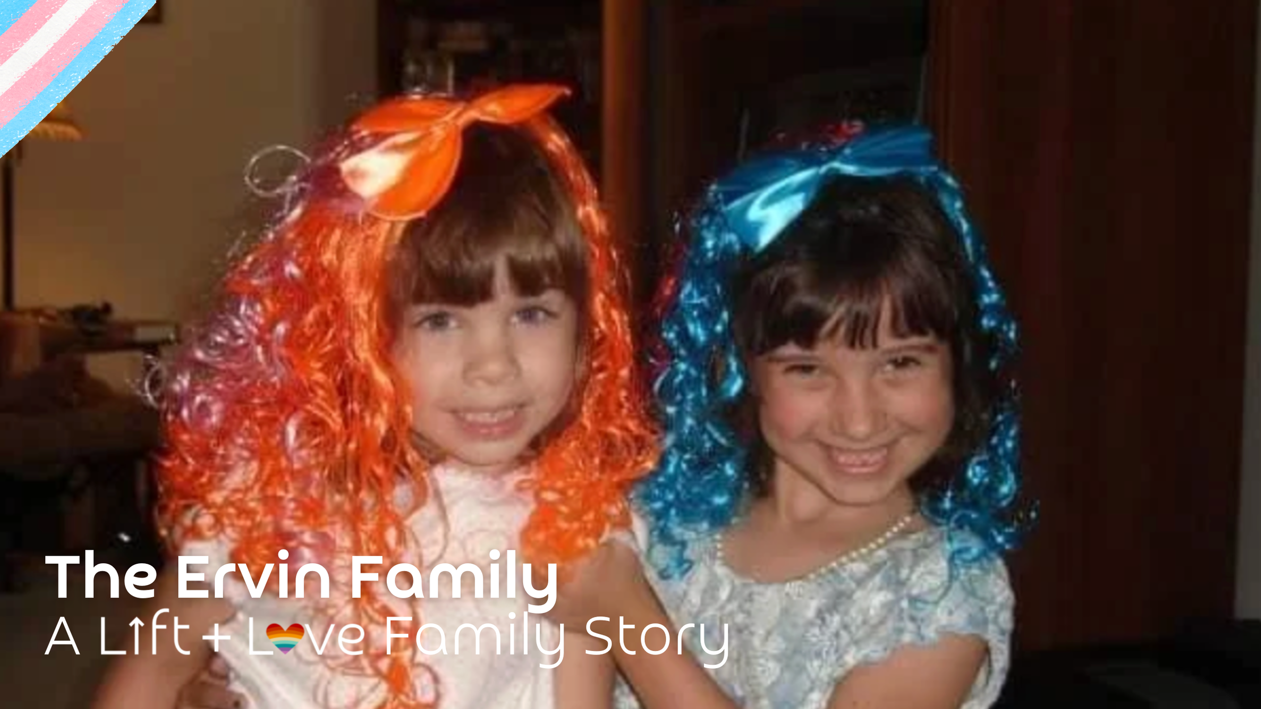 Two young girls with colorful curly wigs, one orange and one blue, smiling and posing together.