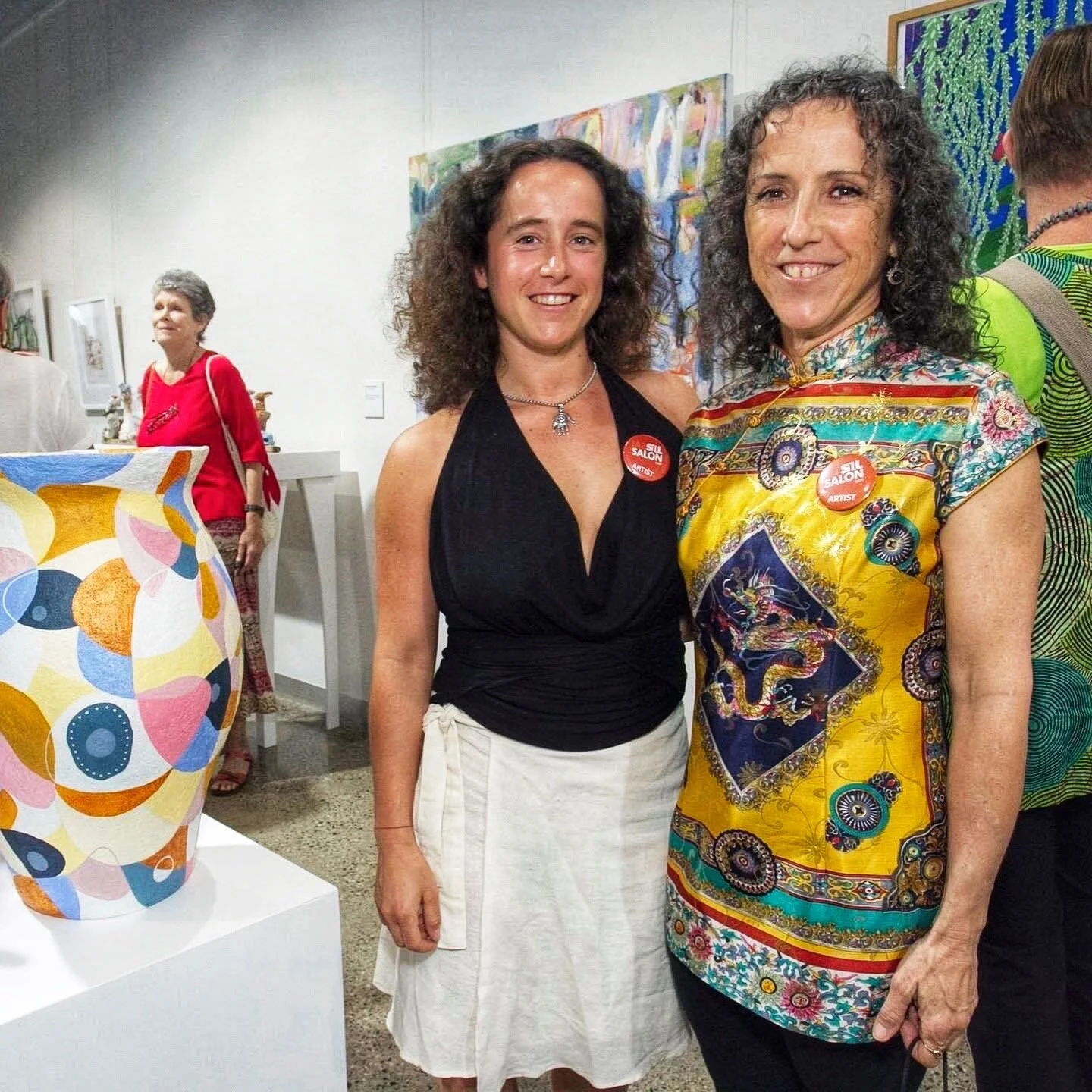 Artists Taylor Meagher and Violeta Laza standing beside their entries at the Still Life exhibition