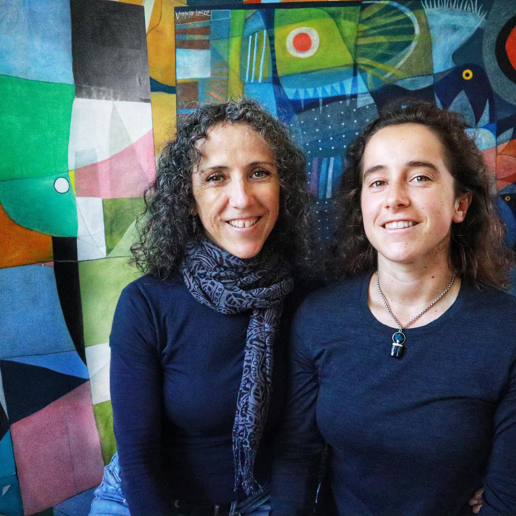 Taylor Meagher and Violeta Lanza in front of colourful abstract painting