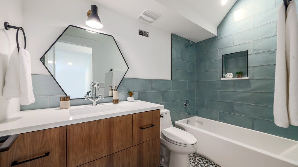 Incredible tile contrasted with a bold mirror in the bathroom