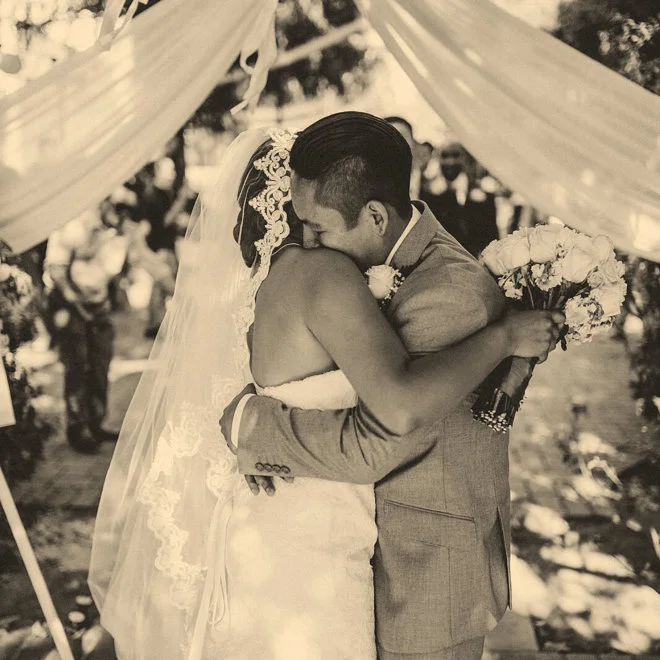 Bride and groom embrace after wedding ceremony in the outdoor garden
