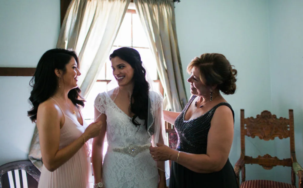 Bride Prepares for Her Wedding Day in Bridal Suite with Support from Maid of Honor and Mother of the Bride