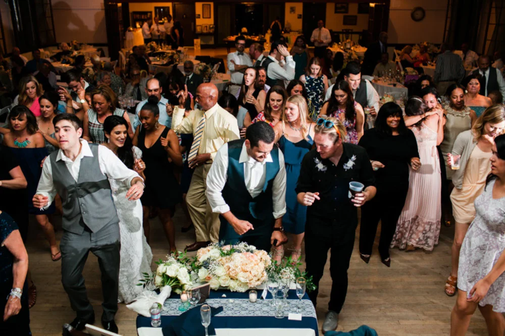 Groom Takes Cues from Best Man and Joins Guests in a Line Dance