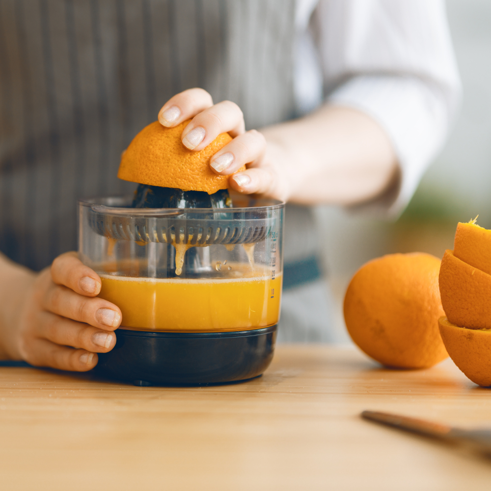 Freshly squeezing orange, lemon, and lime juice for homemade turmeric shots.