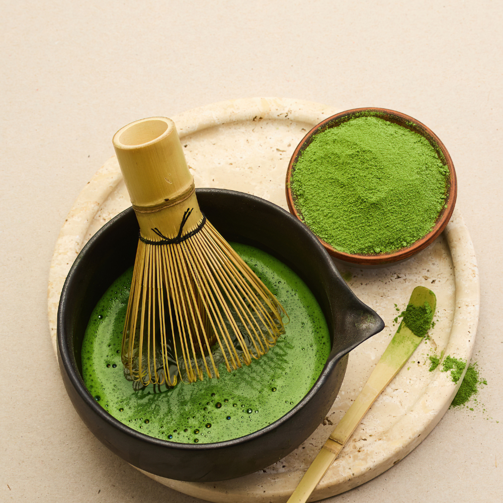Fine matcha powder being sifted into a small bowl for strawberry matcha latte