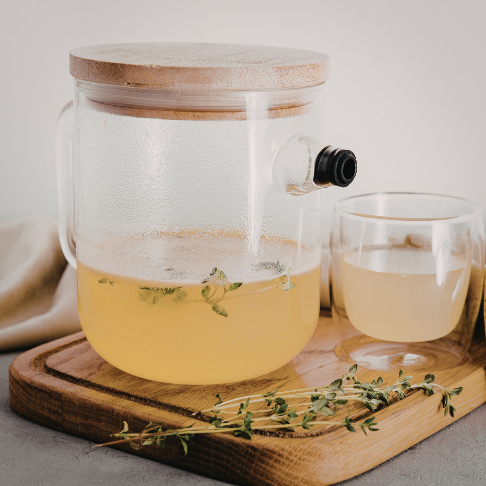 Homemade iced tea in a glass pitcher with ice cubes and citrus garnish.