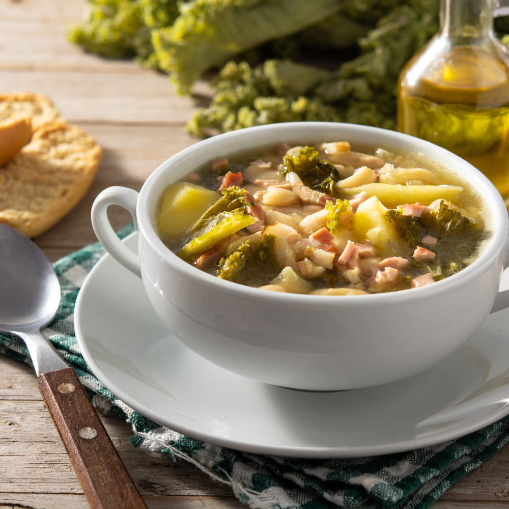 Bowl of homemade ham and bean soup garnished with fresh parsley.