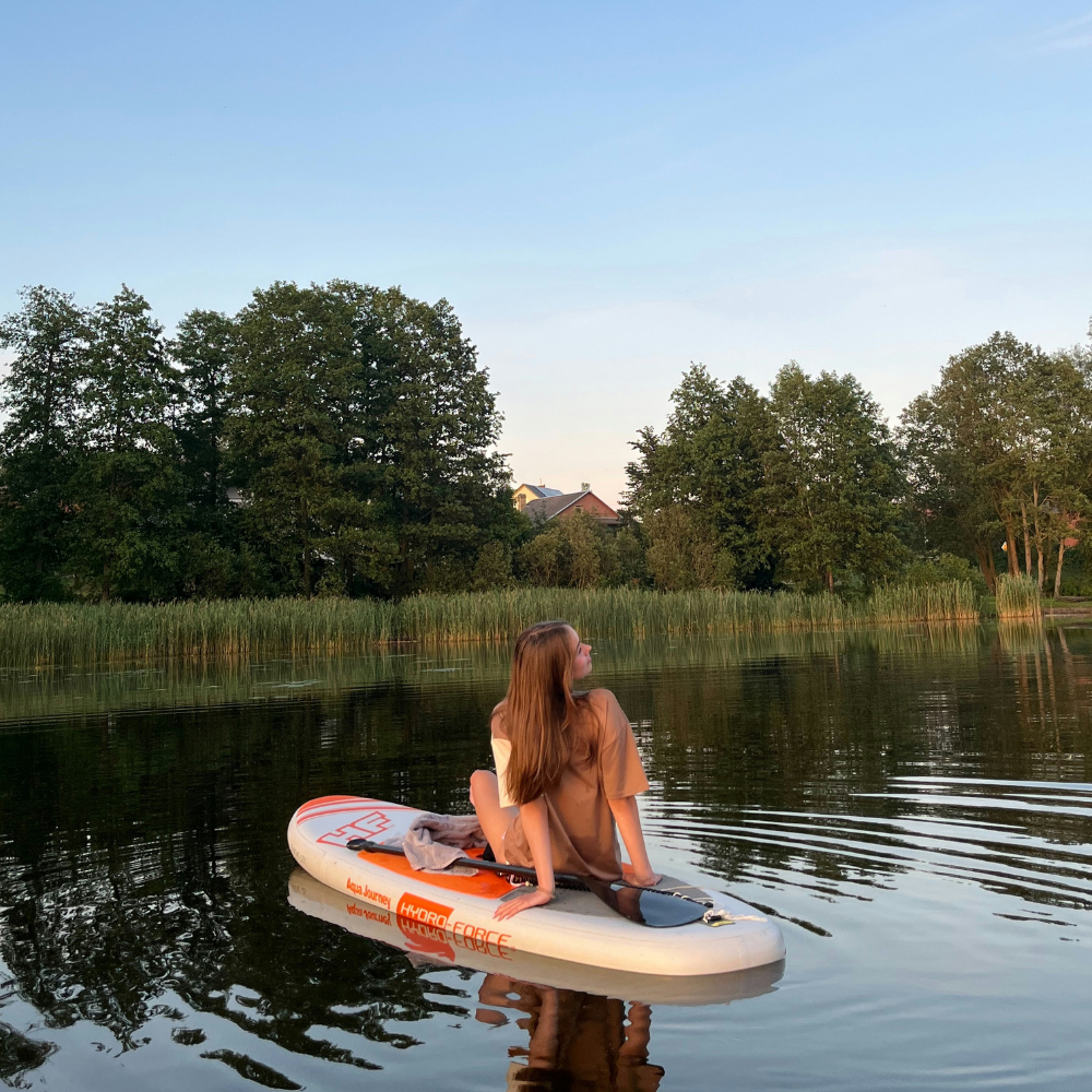 Paddleboarding on a clear alpine lake in Crested Butte surrounded by mountains and wildflowers