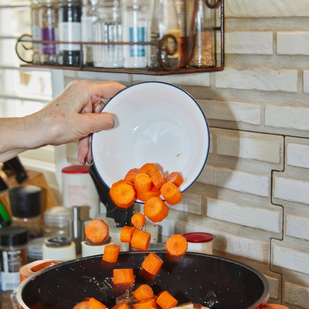 Chopped carrots added to the pot to make carrot ginger soup