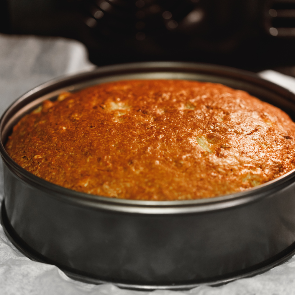 Baked strawberry shortcake cake layer cooling on a wire rack.