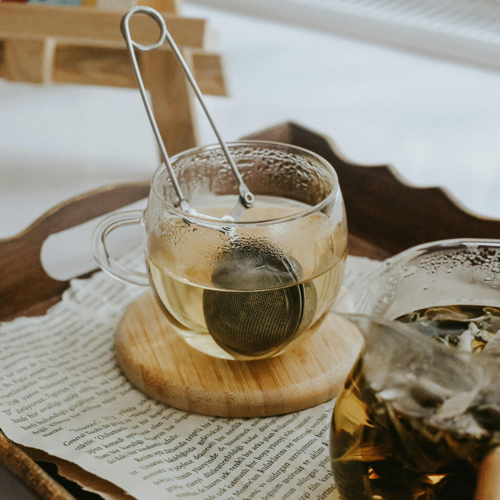 Loose leaf tea steeping in a clear glass jar on the counter.