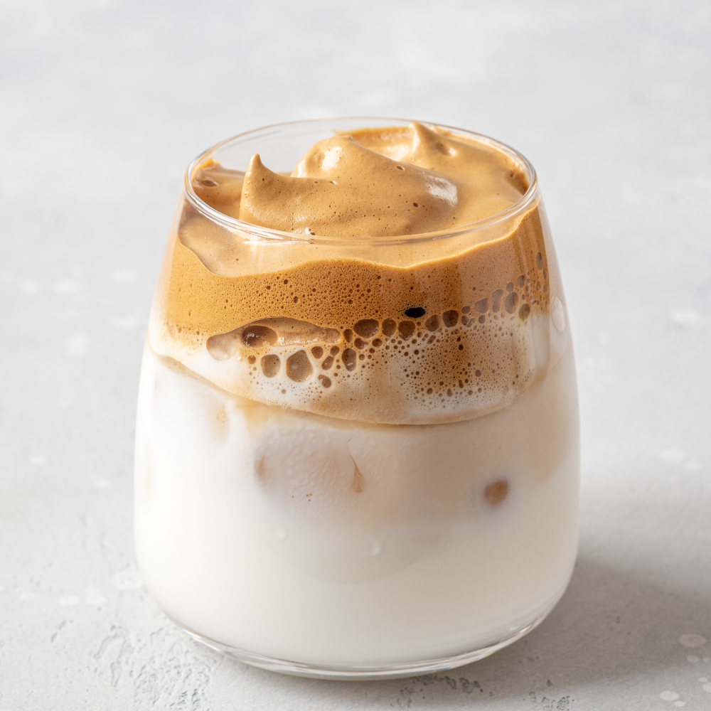 Milk being added to espresso and ice to create a creamy iced latte