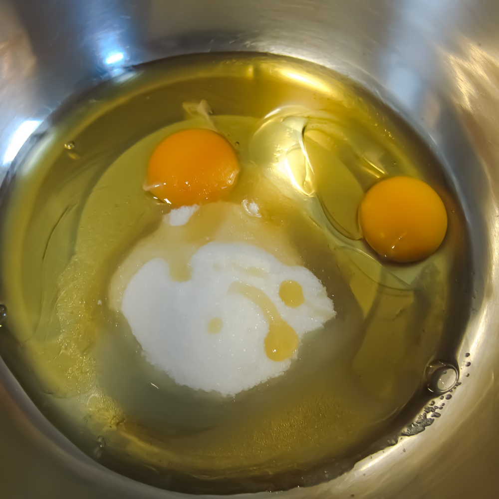 Mixing wet ingredients with a hand mixer for homemade strawberry shortcake.