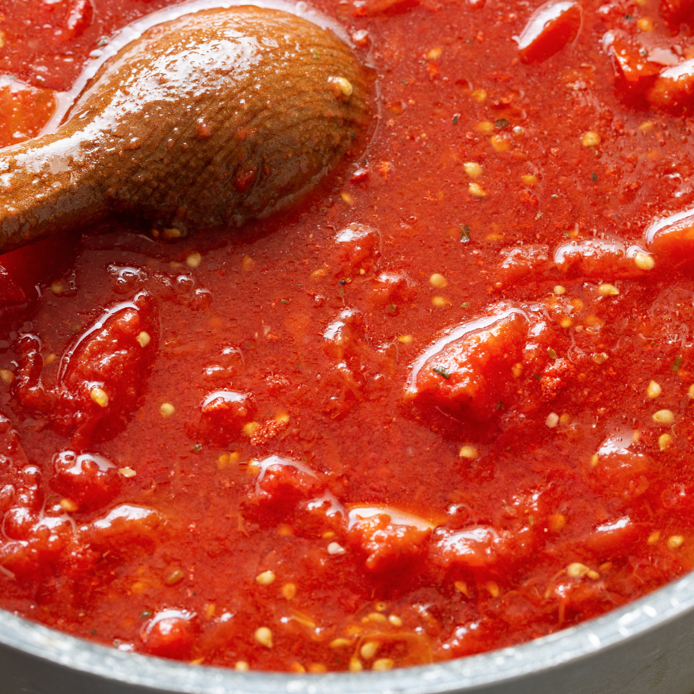 Close-up of homemade pomodoro sauce in a glass bowl, ready to use for pasta or pizza.