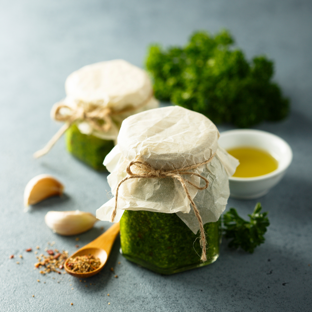 Two jars of homemade kale pesto with vibrant green color, ready to store or serve, for a fresh kale pesto recipe.