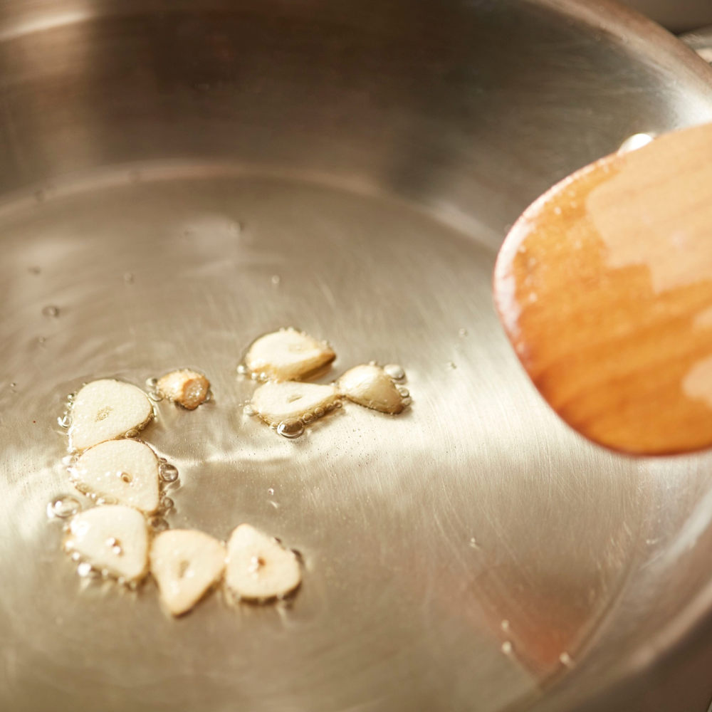 Cooking garlic for a pomodoro sauce for flavor and freshness.