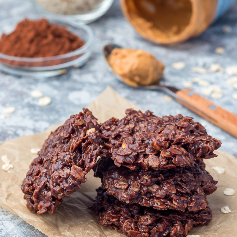 Shaping chocolate peanut butter no-bake cookies onto parchment paper before chilling.