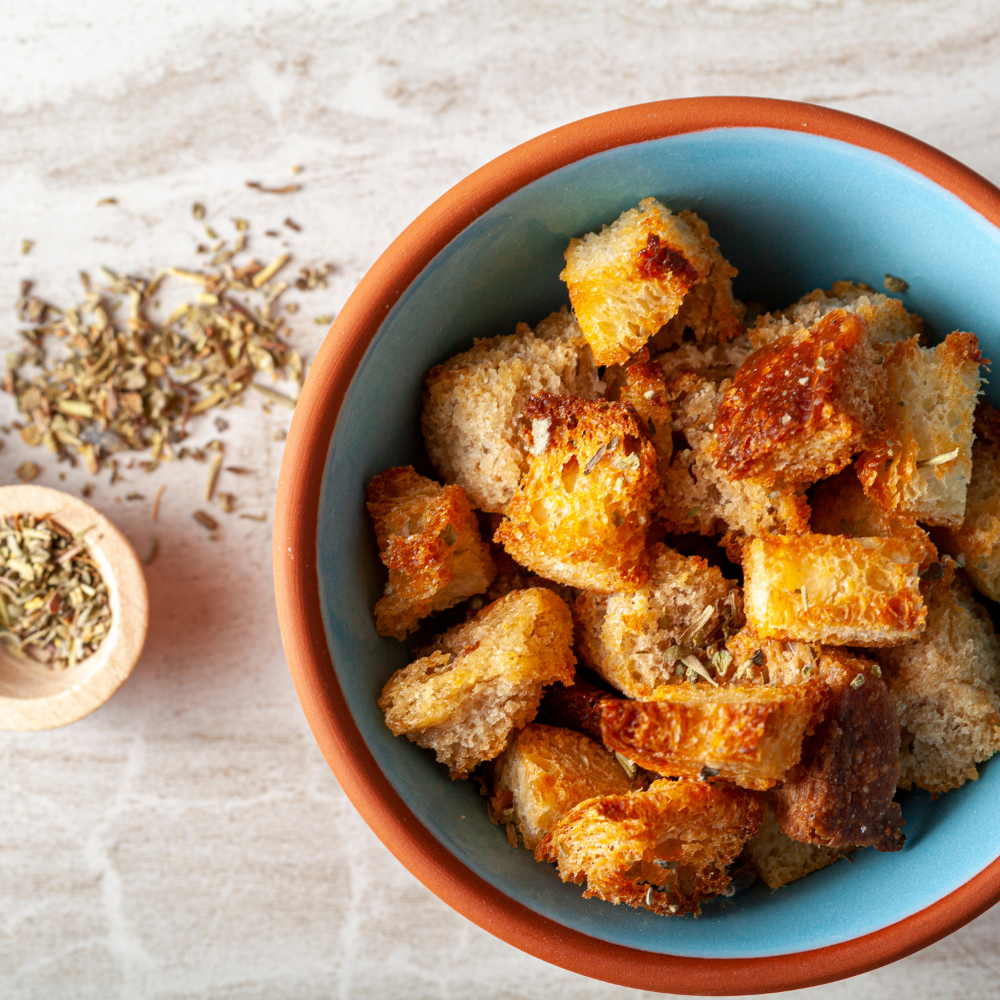 French bread cubes infused with olive oil, garlic, and rosemary for homemade Caesar salad croutons