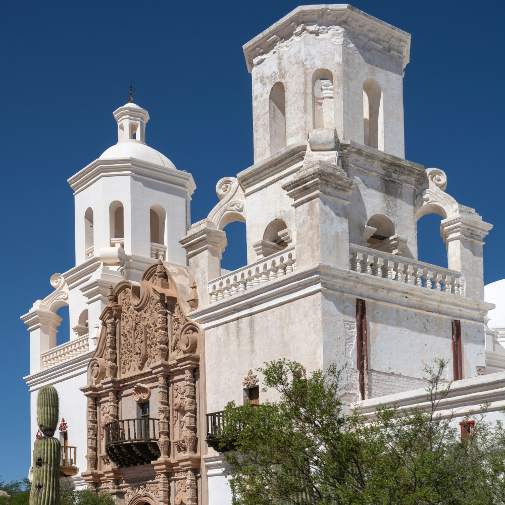Historic white Spanish colonial mission San Xavier del Bac in Tucson Arizona under blue sky.