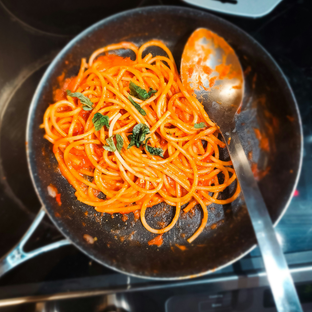 Classic spaghetti al pomodoro topped with fresh basil, made with homemade pomodoro sauce.