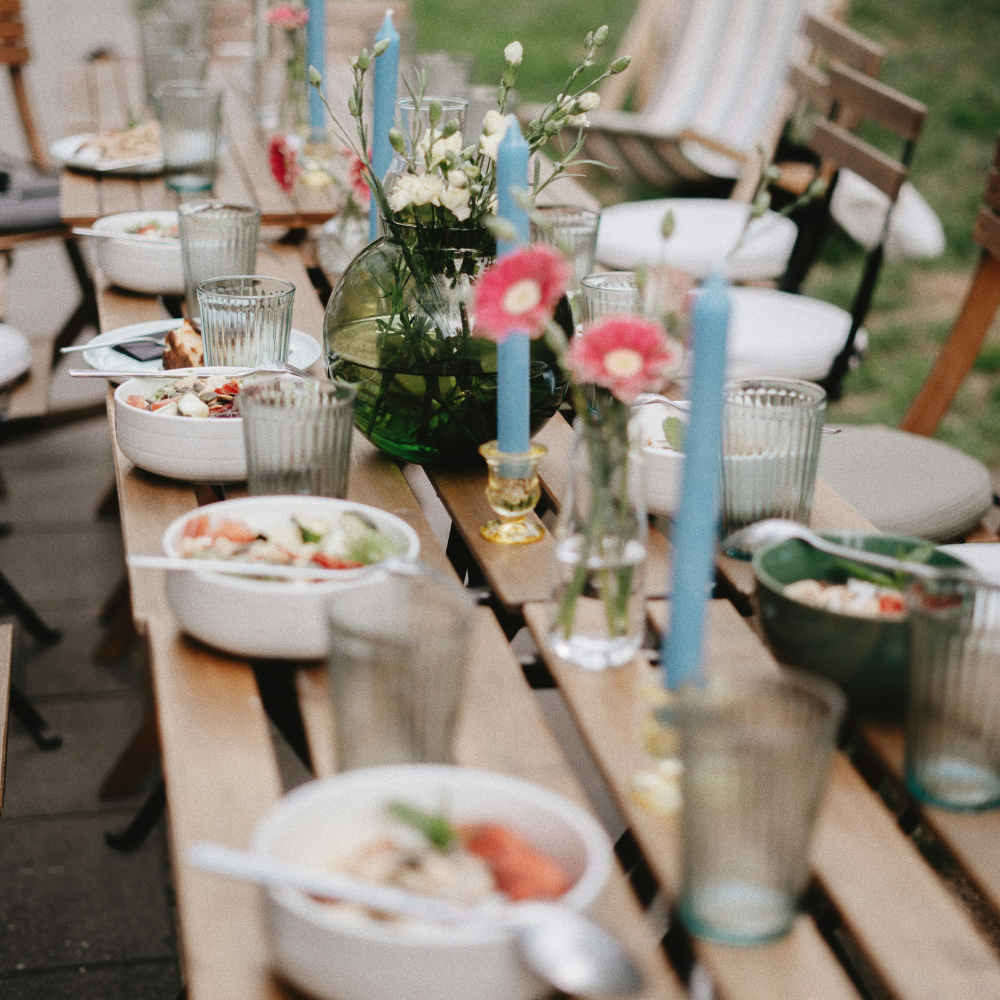Outdoor brunch garden party with pastries, fruit, and brunch bowls on a decorated table
