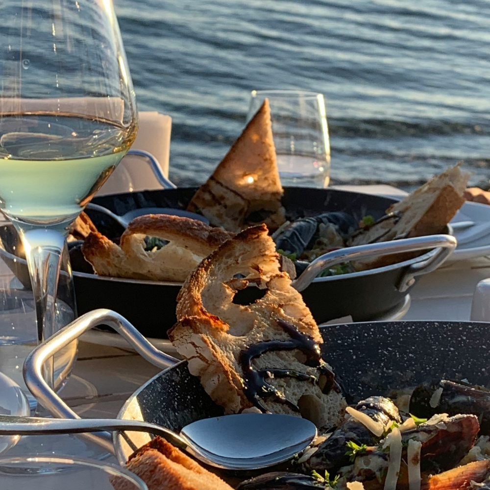 Seafood and drinks at a restaurant near the beach during summer.