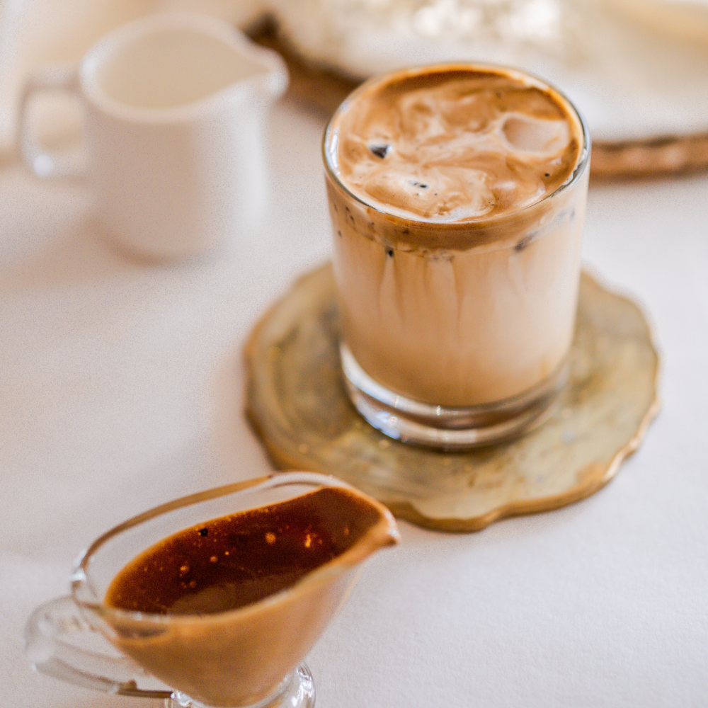 Honey cinnamon iced latte in a tall glass topped with cinnamon, served over ice