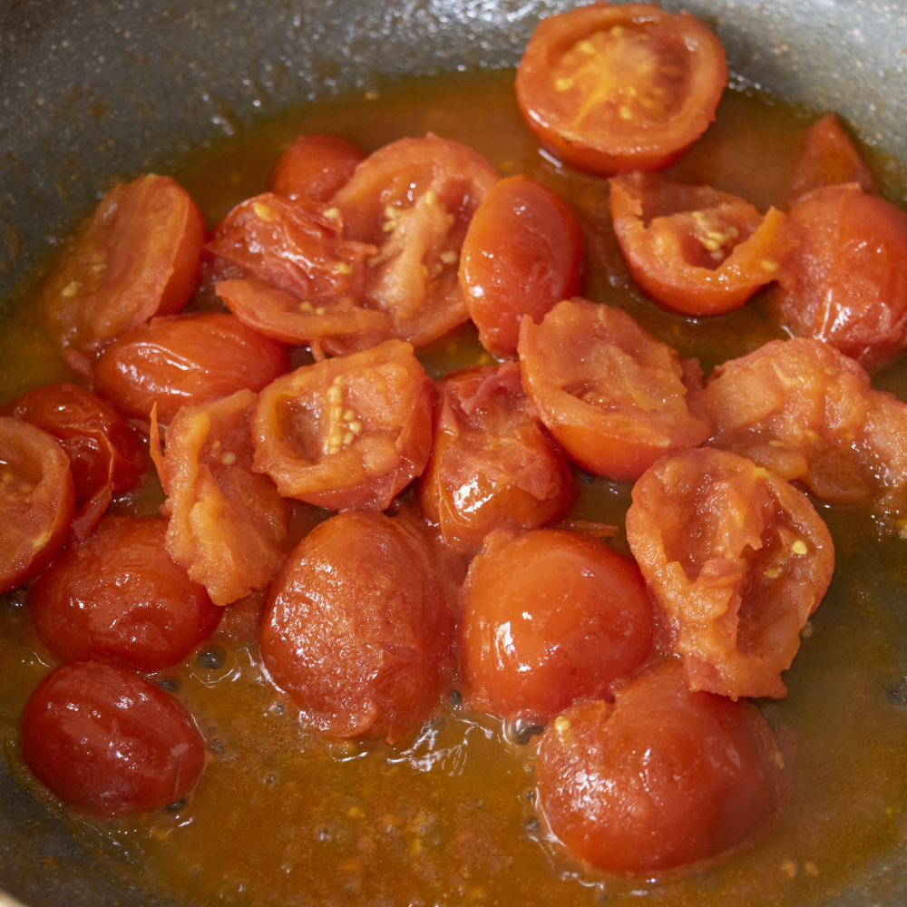 Pomodoro sauce simmering in a pan with garlic and olive oil, a classic Italian tomato sauce preparation.