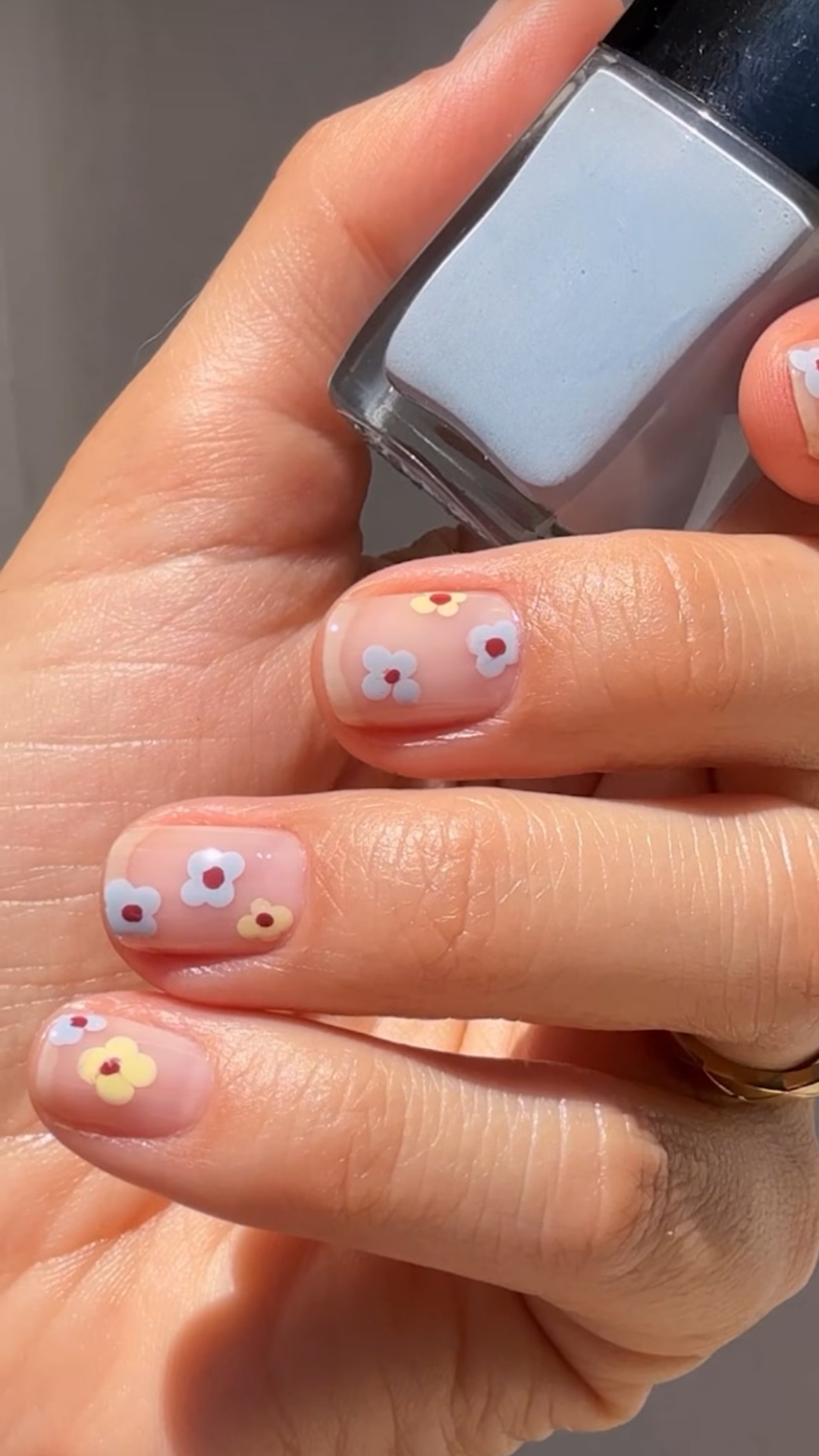 ute spring nail design with tiny white floral accents on nude base