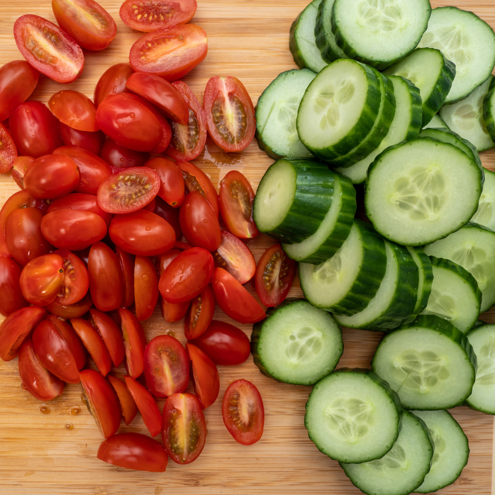Sliced cucumbers and chopped tomatoes prepared for making cucumber tomato salad.
