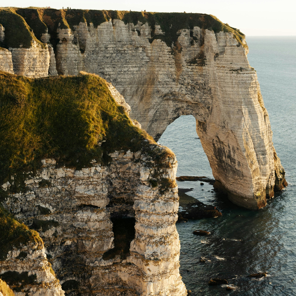 Famous natural arch and coastal cliffs in Étretat, a scenic stop on a Normandy road trip route in France.